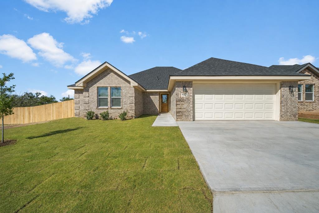 New single-story brick home at 613 Ridgeroad Dr, Big Spring, with a landscaped front yard