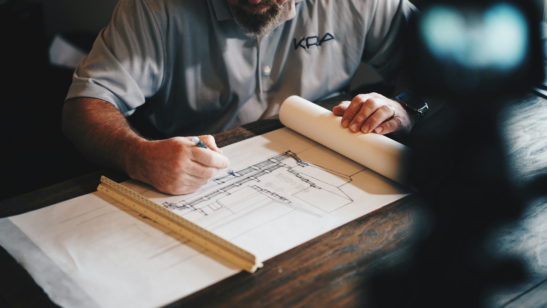 Placeholder photograph of architectural drawings and a workspace